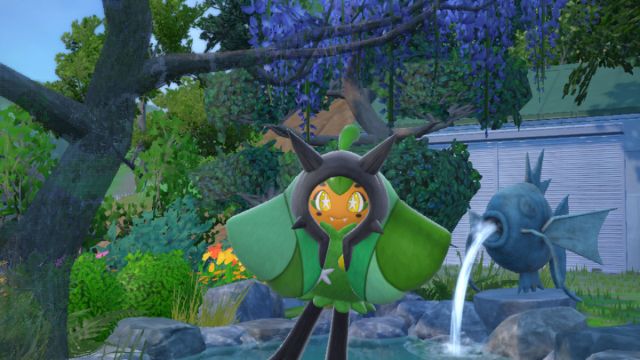 A screenshot of Ogerpon in front of a garden pond in Pokémon Scarlet and Violet: The Teal Mask.