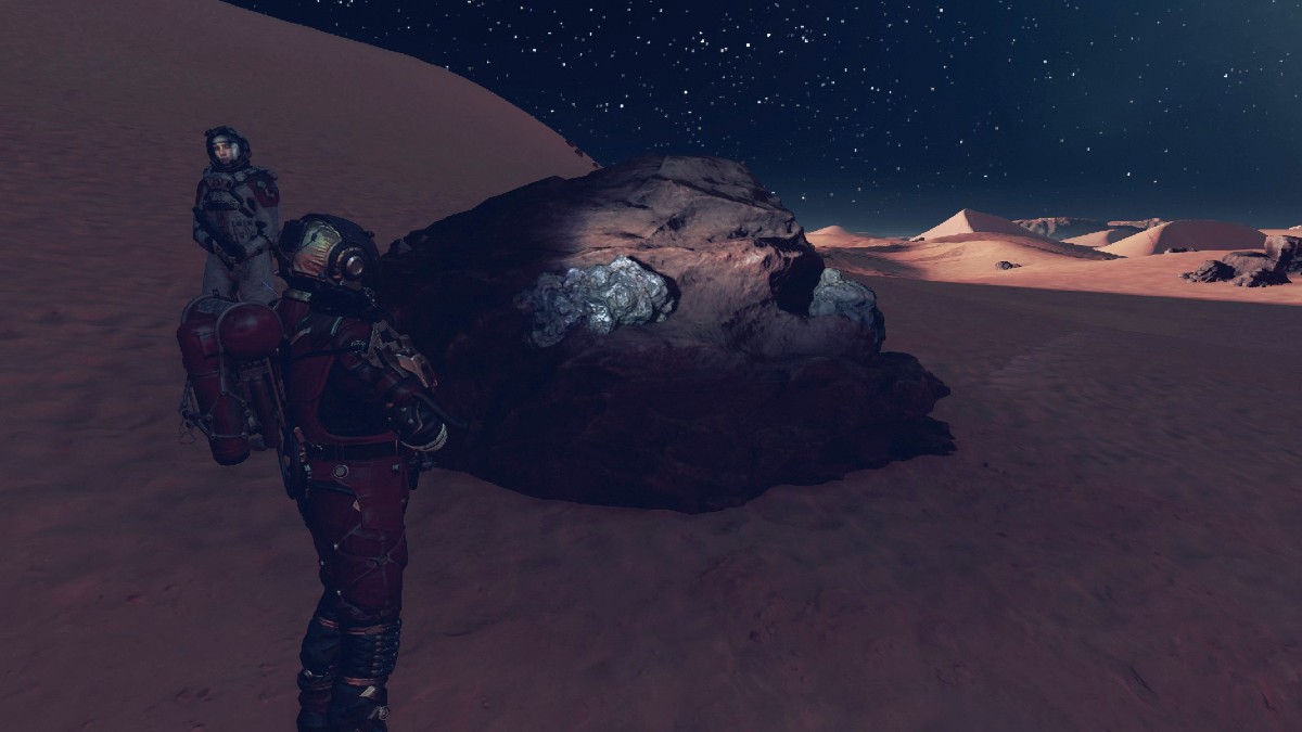 Starfield player character standing in front of a rock housing a Platinum vein.