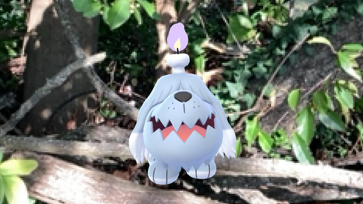 A Pokémon GO AR screenshot of Greavard in some foliage.