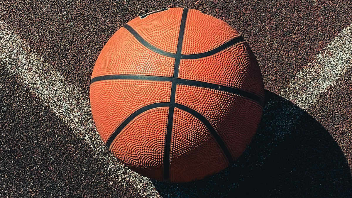A photograph of a basketball on the ground.