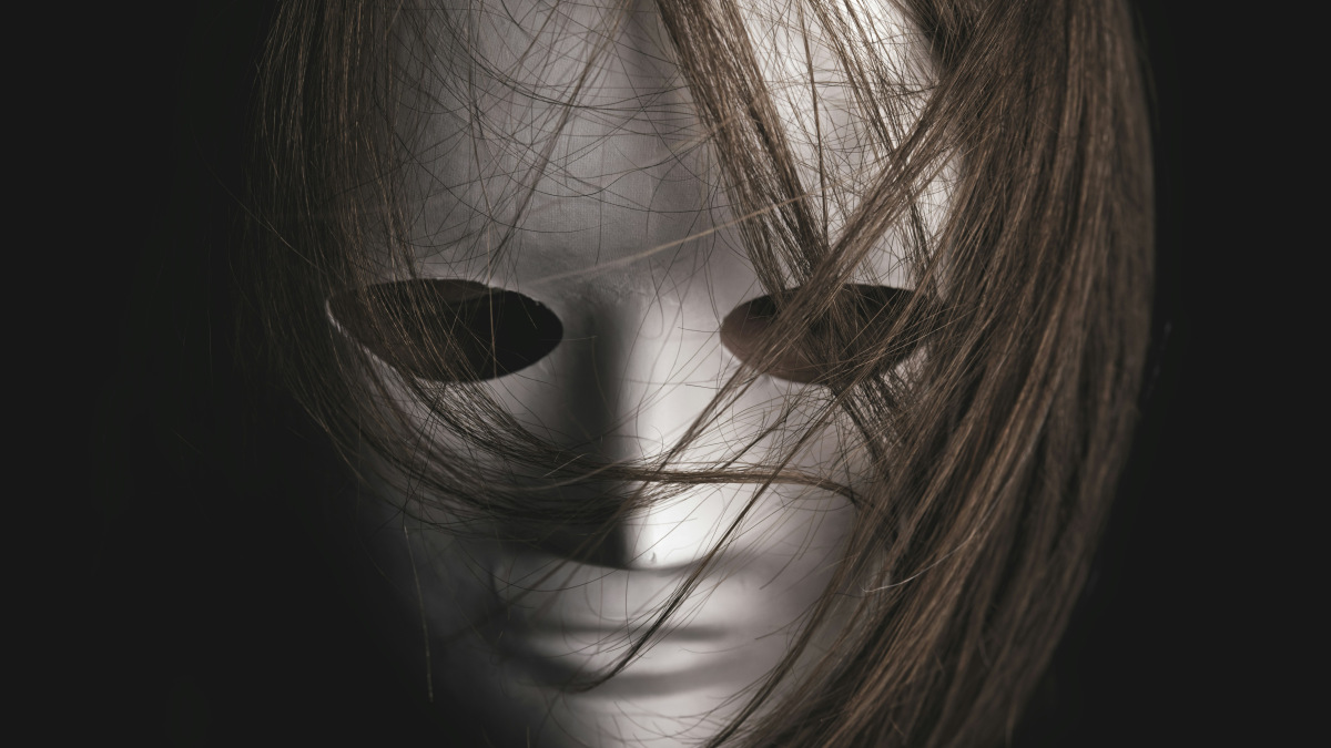 A photograph of a person in a white mask