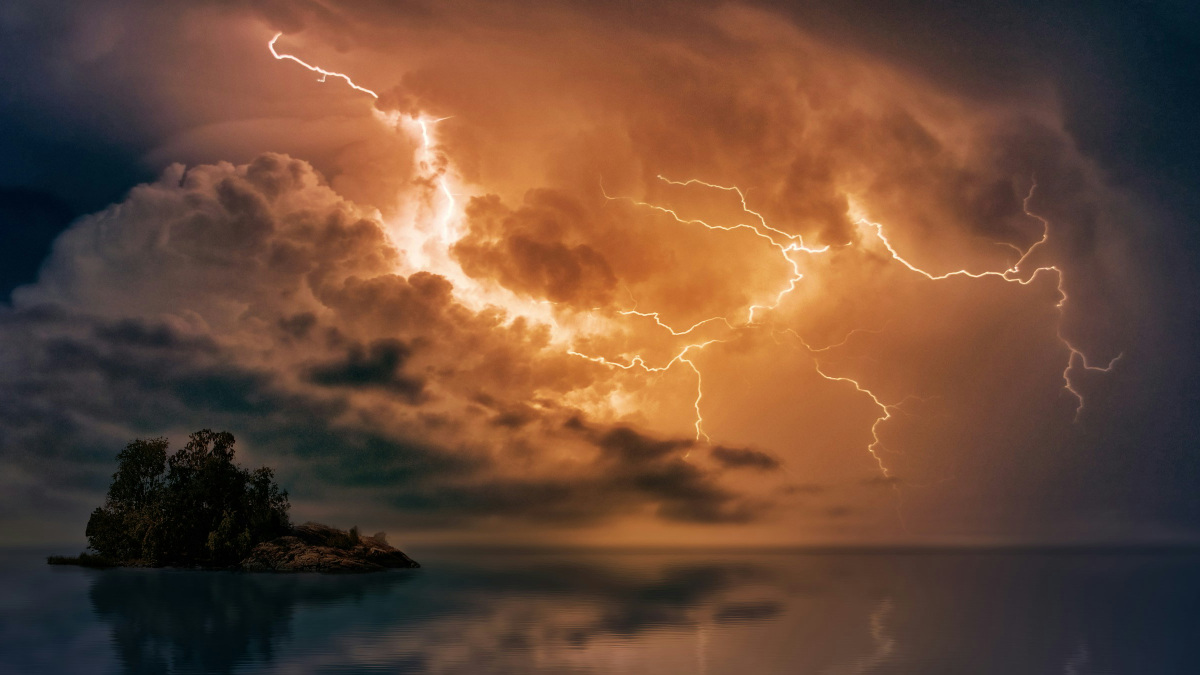 A photograph of an island and lightning in the sky.