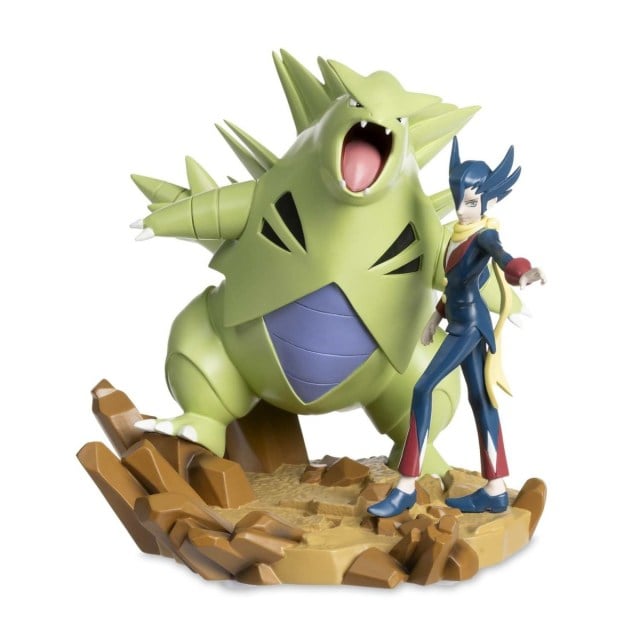 A photograph of a figure of Grimsley with Tyranitar.