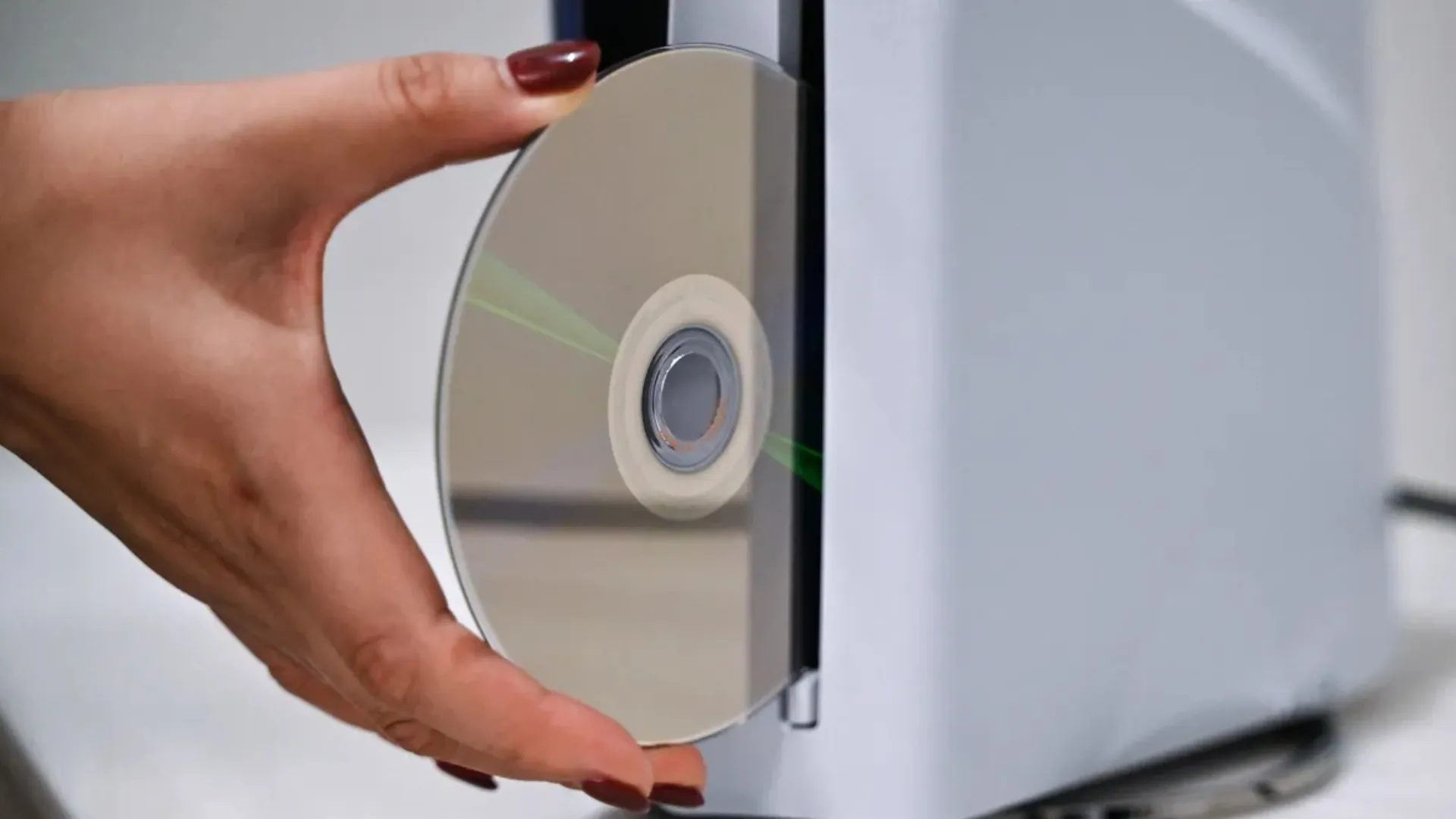 Hand inserting disc inside playstation 5