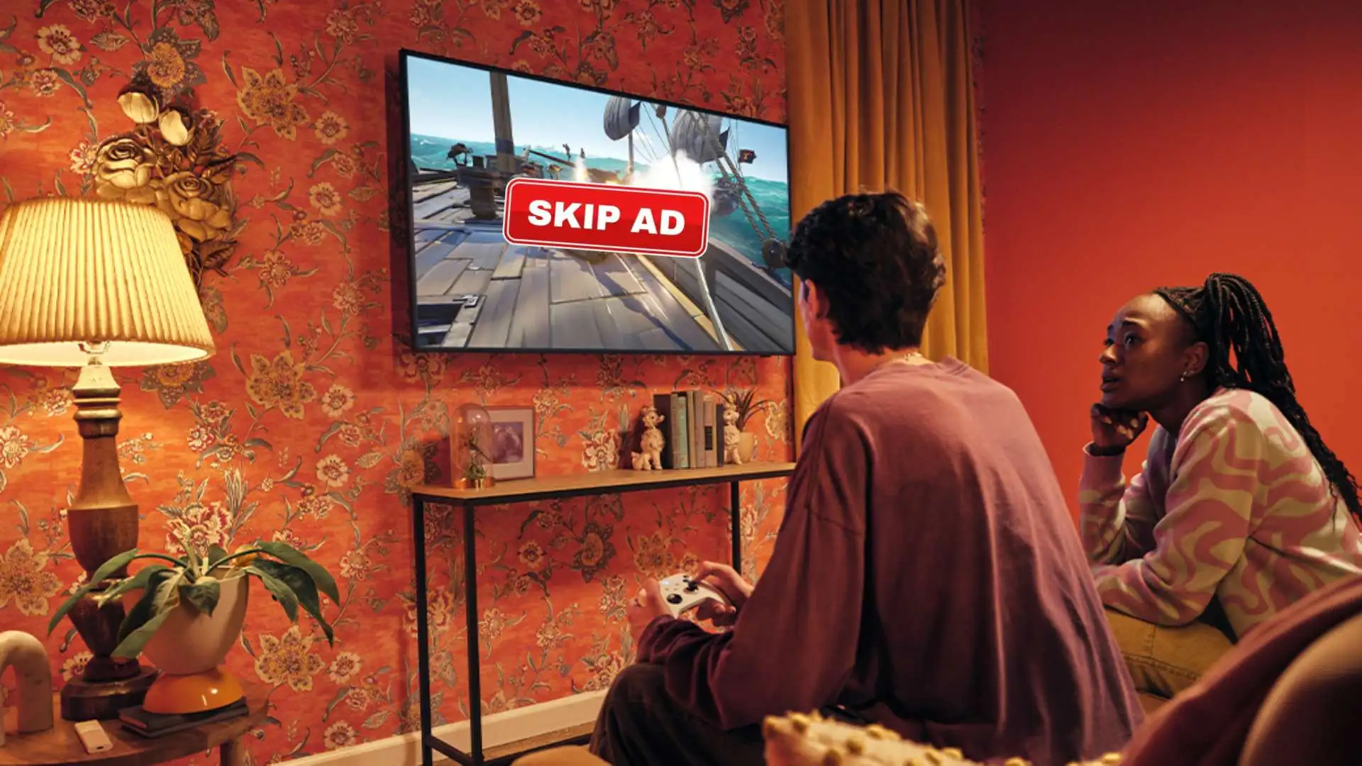 Two gamers sitting on couch waiting for skip ad button on their tv while playing xbox