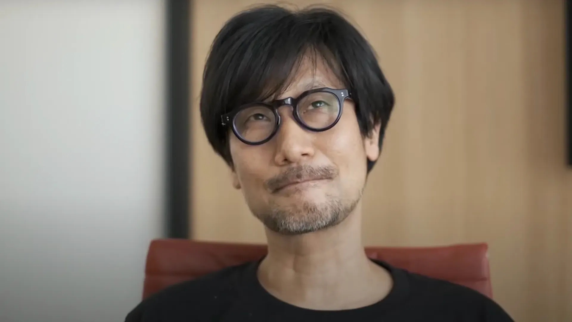 Hideo Kojima sitting in chair thinking